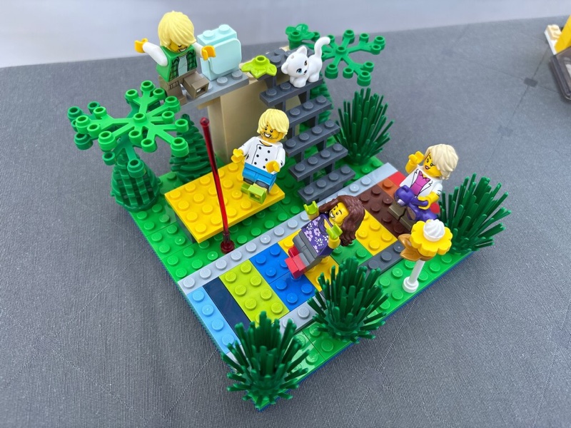 A LEGO® outdoor playground with figures, plants and a cat.