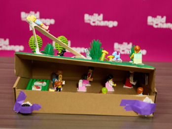 A LEGO® stage scene with figures arranged around a slide.